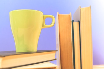 Color cup of tea with books on table