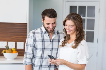 Happy couple looking in mobile phone