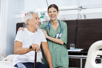 Female Nurse Standing By Senior Patient In Rehab Center