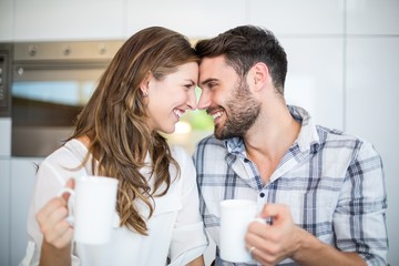 Couple with coffee mug looking at each other