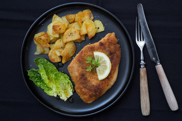 Schnitzel mit Bratkartoffeln Salat und Zitrone