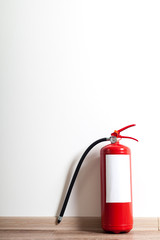 Obraz premium Fire extinguisher near white wall, ready for use