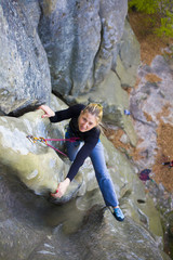 Fototapeta na wymiar The girl climbs on the rock.