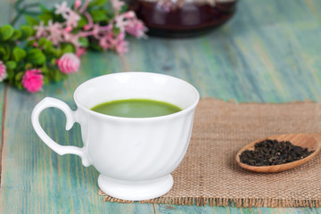 green tea with milk or hot matcha latte on wood