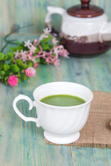 green tea with milk or hot matcha latte on wood