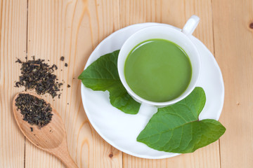 green tea with milk or hot matcha latte on wood