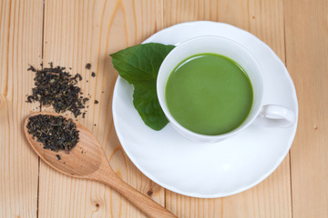 green tea with milk or hot matcha latte on wood
