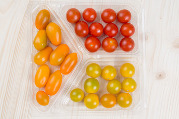 Fresh multicolored cherry tomatoes on wooden background