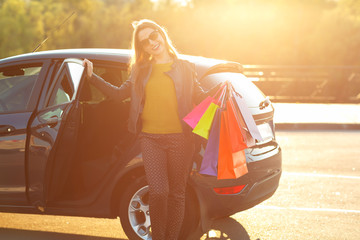 Smiling Caucasian woman putting her shopping bags into the car