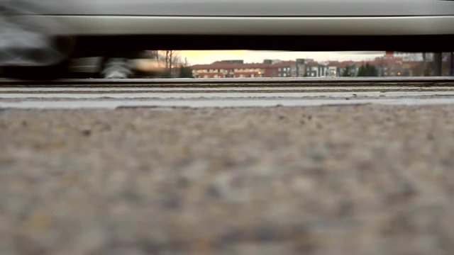 Trafico de automoviles en las dos direcciones en un paso de peatones. Vista lateralmente a nivel del suelo 
