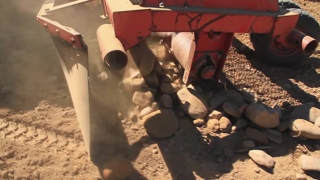 Rastrillo mecanico para recoger piedras de la tierra

