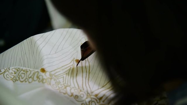 Detail of waxing the drawing to textile for making batik