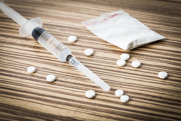 Still life drugs and syringe on table