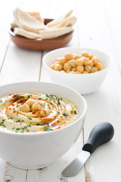 Hummus in bowl on white wooden table