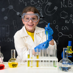 schoolgirl in white gown doing experiments with liquids