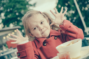 Four years old girl having fun while eating