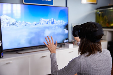 Woman Watching Television Wearing Virtual Reality Headset