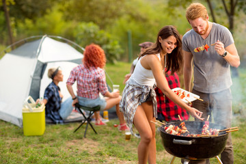 Young brunette with boyfriend serving on plate barbecue - obrazy, fototapety, plakaty