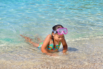 Adorable toddler girl enjoying her summer vacation at beach