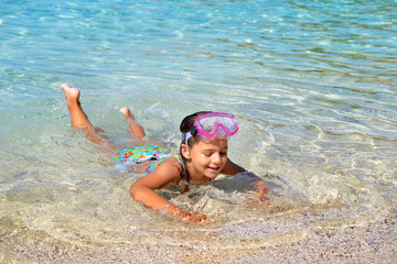 Adorable toddler girl enjoying her summer vacation at beach