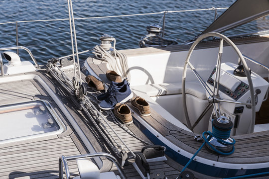 three pairs of shoes in a yacht’s wooden deck