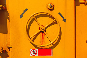flywheel on the ship's doors. Iron circle wheel on the door of yellow ship