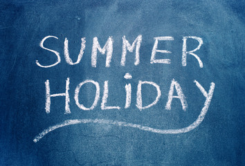 Fototapeta na wymiar Summer holiday text on blue chalkboard.