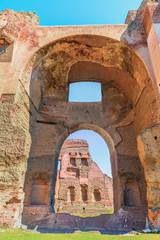 Picturesque view through arch on the ruins of the ancient roman Baths of Caracalla ( Thermae Antoninianae ) at  sunny day.Famous architectural landmark built between AD 212 - 217.Rome. Italy. Europe.