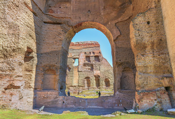 Beautiful view through arch on the ruins of the ancient roman Baths of Caracalla ( Thermae Antoninianae ) at  sunny day.Famous architectural landmark built between AD 212 and 217.Rome. Italy. Europe.