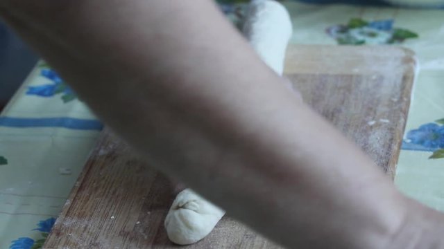 Baker kneading dough on cutting board