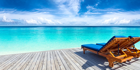 sun lounger bed on jetty in front of paradise ocean beach / Sonnenliege auf Steg vor türkis farbenen Meer Paradies mit Traumstrand 