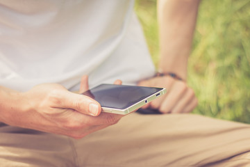 Smartphone in Männerhand, draußen