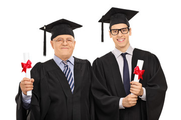 Mature and young man posing with diplomas