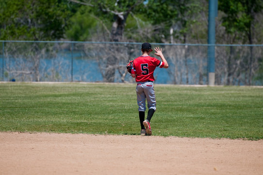 Teenage baseball shortstop from behind.