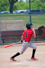 American teen baseball player swinging the bat.