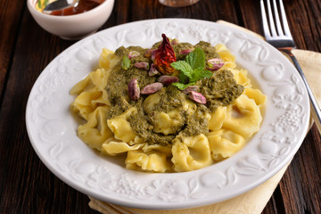 Cappelletti pasta with pistachio and red pepper on the table
