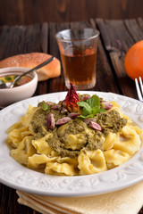 Cappelletti pasta with pistachio and red pepper on the table