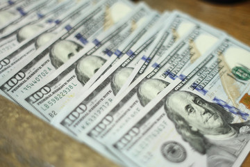 Hundred Dollar bills laid out in a line.	