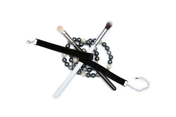 MakeUp brushes covered with black ribbon and beading isolated