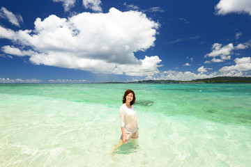 Fototapeta na wymiar 水納島のビーチで遊ぶ笑顔の女性 