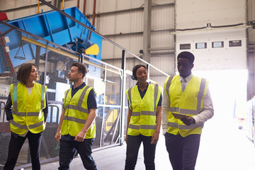 Supervisor and coworkers walking in an industrial interior