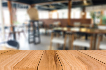Selected focus empty brown wooden table and Coffee shop blur bac