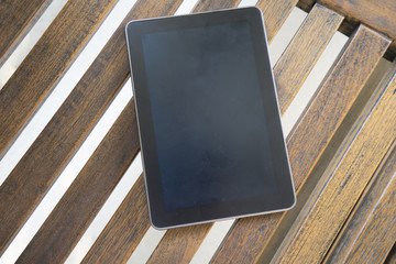 digital tablet on wooden bench