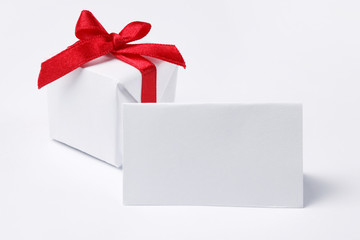 White gift box with red ribbon and tag