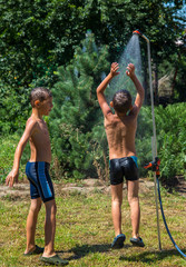 Boys under a shower in the garden