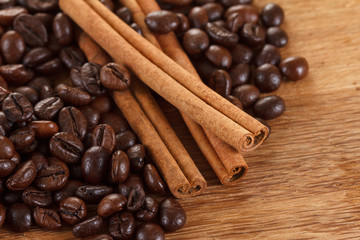 Coffee beans with cinnamon and anise on wooden table