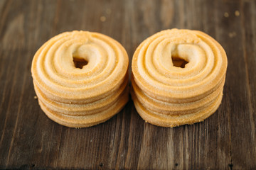 tasty butter biscuit rings on wooden background