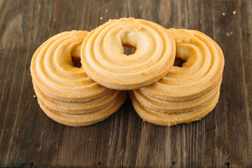 tasty butter biscuit rings on wooden background