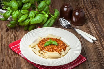 Penne a bolognese on white plate.