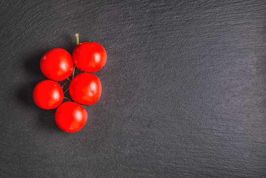 view from above of beautiful red tomatoes on slate stone backgro
